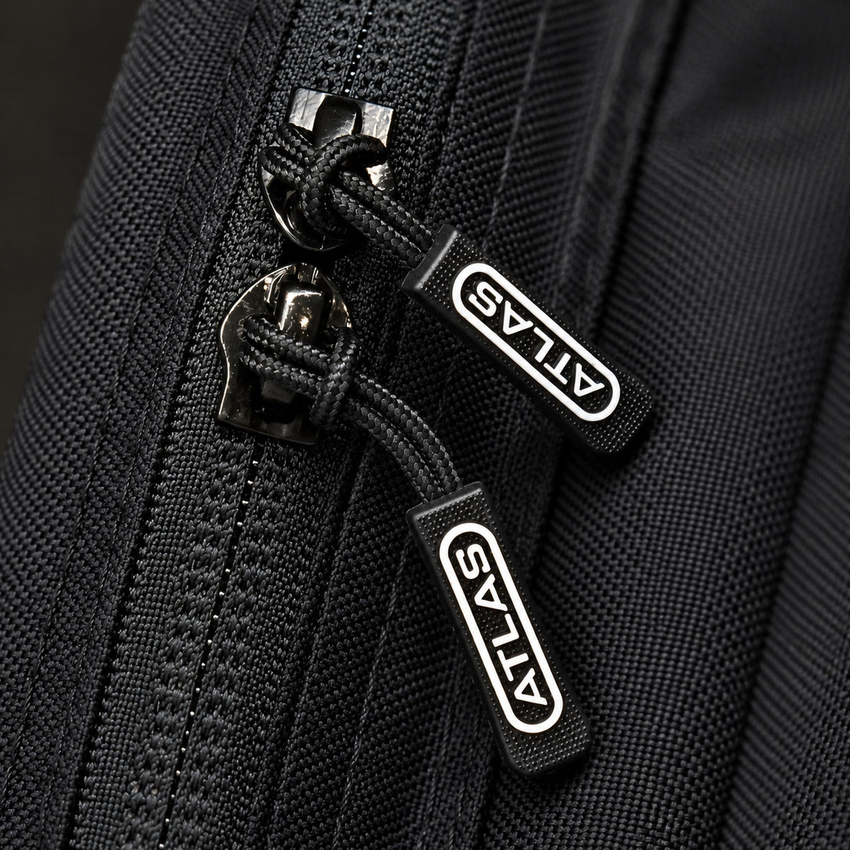 ATLAS branded zip pulls, close-up